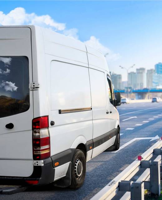 White van moving on the route at modern cityscape background. Small Truck delivers the goods